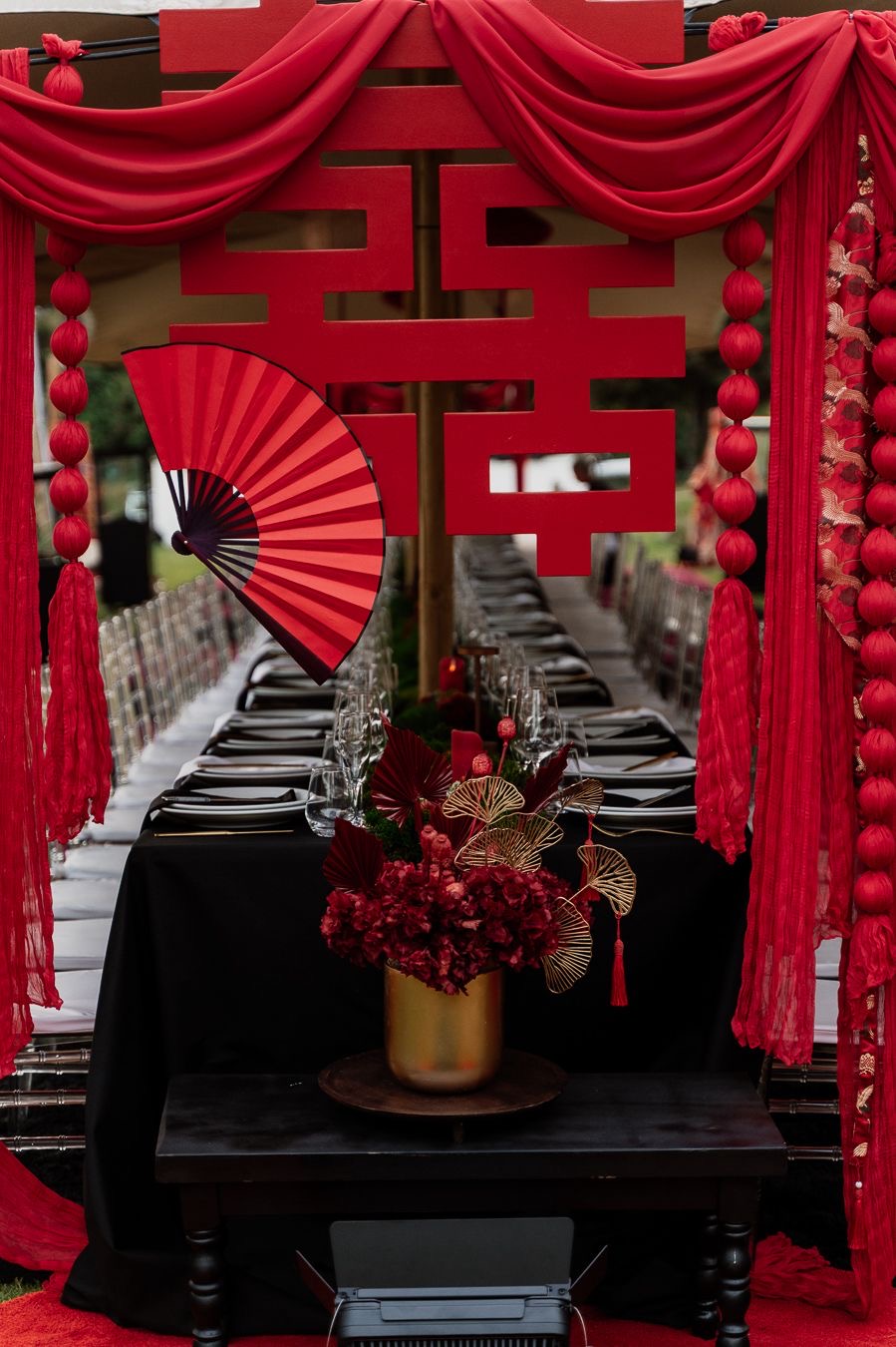 Immersive red dinner installation with sculptural draping and floral design